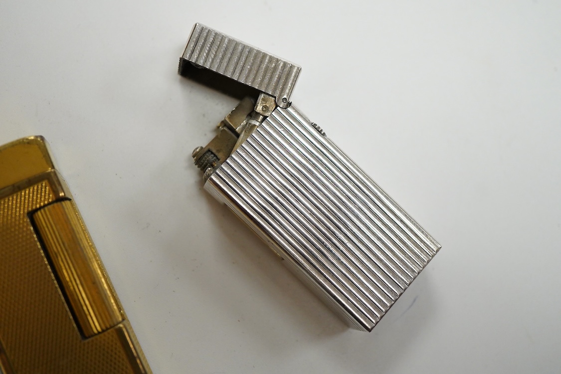 Three assorted plated Dunhill lighters and a gilt example, largest 6.5cm high